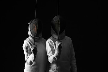 Young fencers on dark background