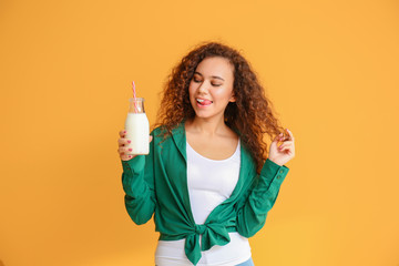 Young African-American woman with milk on color background