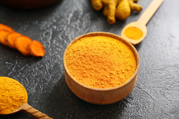Bowl with aromatic turmeric powder on table
