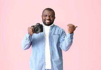 African-American photographer on color background