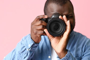 Fototapeta premium African-American photographer on color background