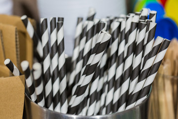Munich, Bavaria / Germany - Feb 15, 2020: Close up of drinking straws in a metallic jar. Black & white striped - like coffee and milk. For drinking latte macchiato. Must have for every good barista.