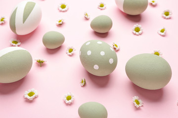 Beautiful Easter eggs and flowers on color background