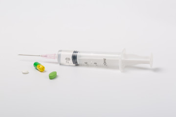  Syringe and miniature human and oral medicine and thermometer macro closeup on white background