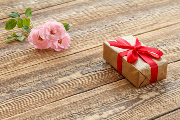 Fototapeta na wymiar Gift box on wooden boards with pink roses