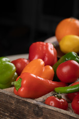 Color peppers in a wooden tray.