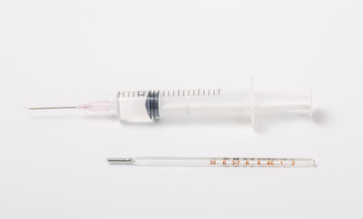  Syringe and miniature human and oral medicine and thermometer macro closeup on white background