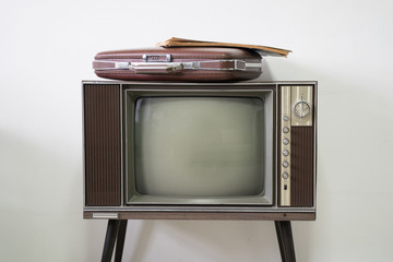 Old vintage briefcase on old television in white room