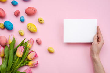 Easter eggs and greetings card on pink background