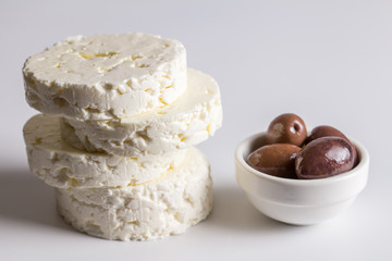 Feta style cheese and black olives made and grown in South Africa isolated on white