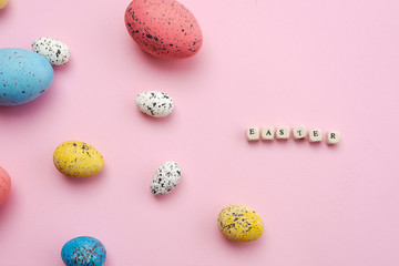 Happy Easter concept. Colorful eggs are laid out on a cute, pink background.