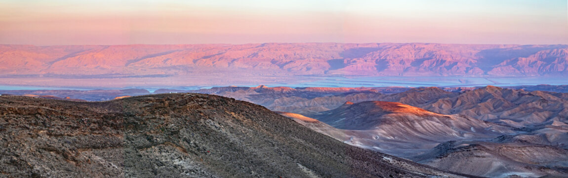colorful panorama of the sun setting on the moav mountains in jordan and the dead sea from the negev desert hills near Arad in Israel