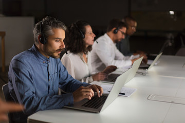 Serious call center operators during working process. Confident client support team at workplace. Call center concept