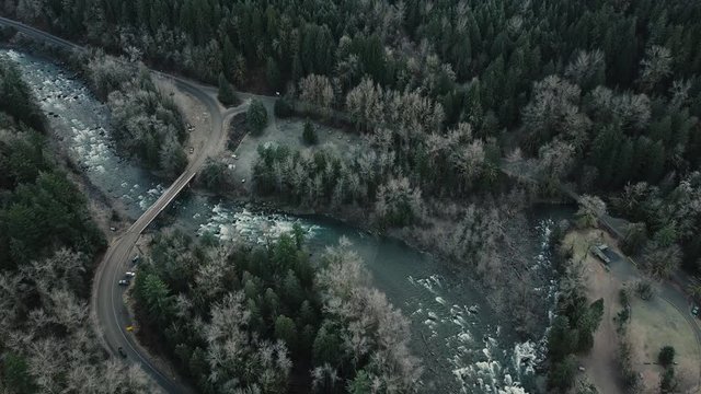 Fly over s-shape road and a small car crossing a bridge over the beautiful blue river