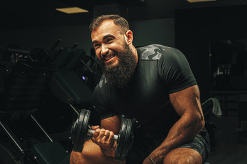 Obraz na płótnie Canvas Male with sport body lifting dumbbells at the gym