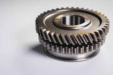 New parts on a gray background. Gears of gear shifting torque transmission. Conceptually mechanical background. Shiny gear box gear teeth