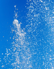 Naklejka na ściany i meble Splashing water from a fountain on a background of blue sky