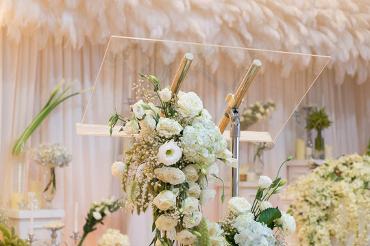 Flower decoration on transparent podium with backdrop and candles
