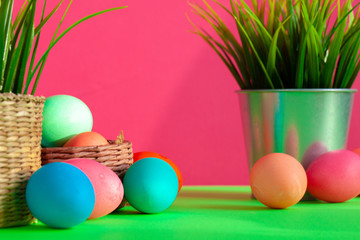 Vibrant colored eggs in a nest on green. Easter concept