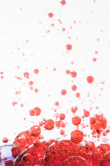 Red bubbles in water with white background. Abstract photography
