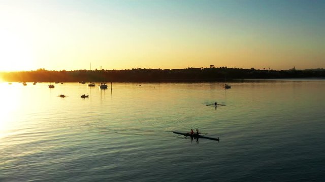 Vibrant aerial sunset above Auckland port with double scull in forefront