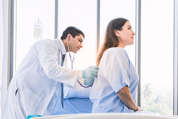 Obraz premium Asian doctor check-up pretty patient from her back for her backache healthy at hospital or medical clinic