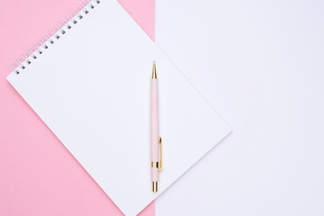 pink pen over note book on white background