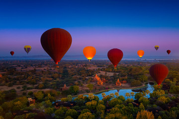 Fototapeta premium Sunset many hot air balloon with stupas in Bagan, Myanmar. Bagan is an ancient with many pagoda of historic buddhist temples and stupas. space for text.
