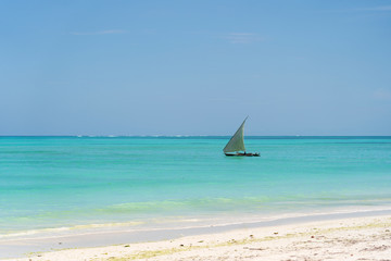 Sailing ship and blue sky over sea water waves on the island of Zanzibar, Tanzania, Africa. Travel and nature concept