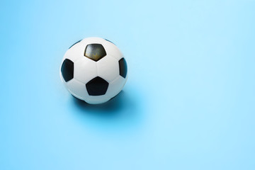 Miniature soccer ball on a blue background. World championship. Physical development of the child. How much does health cost? Sports and money.