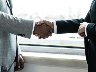 Male and female partners closing deal or agreement. Closeup os business man and woman shaking hands with each other. Contract or partnership concept