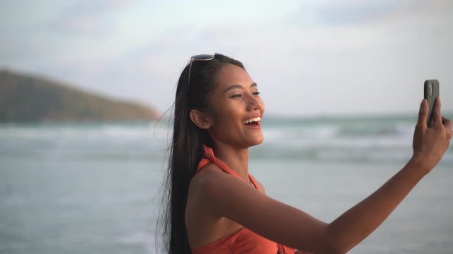 Beautiful sexy bikini african woman black skin taking selfie photos using smartphone on the beach sunset 4K Resolution