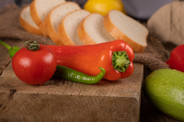 Tomato, chilies and bread on a wooden board