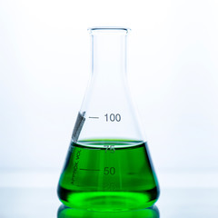 green chemical liquid containing in flask white background, lab research and development concept.	