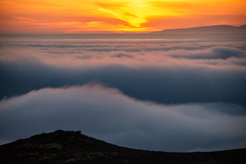  Dreamy misty landscape above the sea of clouds, mountains at sunset in Iceland