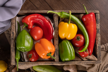 Colorful peppers and hcilies in a rustic space. top view