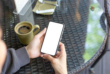 Mockup image blank white screen cell phone.man hand holding texting using mobile on desk at coffee shop.background empty space for advertise text.people contact marketing business,technology
