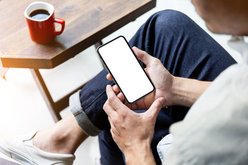 Mockup image blank white screen cell phone.man hand holding texting using mobile on desk at coffee shop.background empty space for advertise text.people contact marketing business,technology