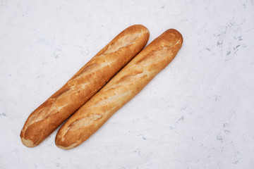 Three baguettes on the wooden background