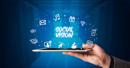 Young business person working on tablet and shows the inscription: SOCIAL VISION