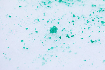 spots of green paint on white snow