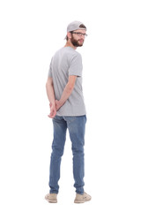 Fototapeta premium rear view. casual guy in cap reading ad on white wall