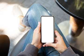 Mockup image blank white screen cell phone.man hand holding texting using mobile on desk at coffee shop.background empty space for advertise text.people contact marketing business,technology