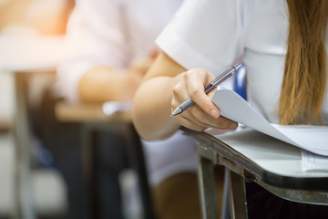 high school,university student study.hands holding pencil writing paper answer sheet.sitting lecture chair taking final exam attending in examination classroom.concept scholarship for education abroad