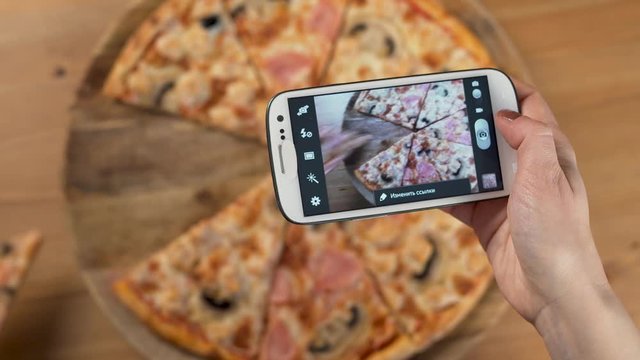 A Woman Takes Photos Of Delicious Pizza For Dinner With Her Hands Using A Smartphone. Close up. 4K