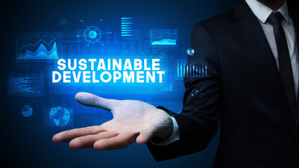 Hand of Businessman holding SUSTAINABLE DEVELOPMENT inscription, business success concept