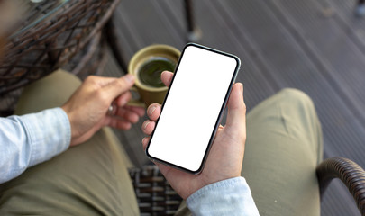 Mockup image blank white screen cell phone.man hand holding texting using mobile on desk at coffee shop.background empty space for advertise text.people contact marketing business,technology