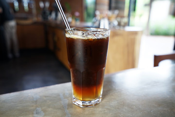 Close up glass of Iced black Americano coffee with stainless steel straw