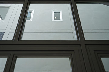 Close up detail and design of metal mirror glass frame with building outside