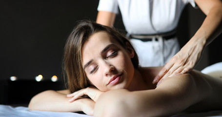 Masseur doing massage on woman body in the spa salon. Beauty treatment concept.